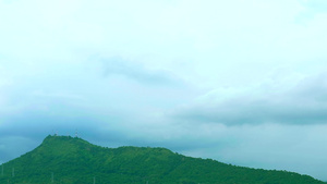 雨在天上暴云随风而移动穿过绿色的顶峰山16秒视频