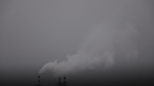 在一个雾蒙蒙的冬日烟雾从工厂的烟囱里冒出来视频