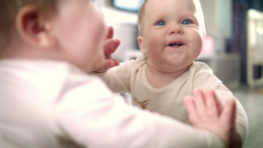 新出生的婴儿笑玩镜子反射的游戏视频