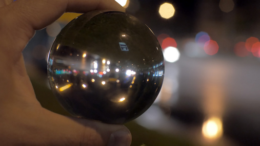 透过玻璃球看着夜间城市视频