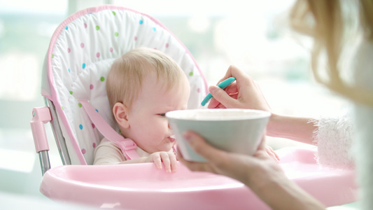 用婴儿食品喂幼的母亲托德勒女孩吃纯净食品视频
