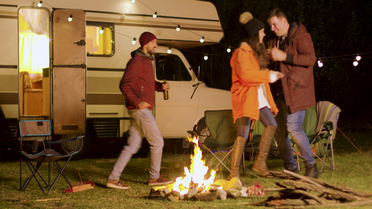 一群亲密朋友在秋天寒冷的夜晚在营火周围跳舞视频