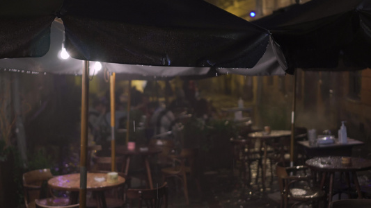 雨中的夜生活户外老城街边咖啡馆的雨夜无法辨认的人喝酒视频