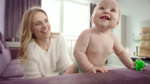 可爱的婴儿手拿着玩具站起来可爱的婴儿学会走路25秒视频