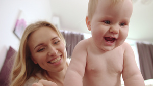 带着5个牙齿笑的小婴儿和背后扶着他微笑的母亲29秒视频