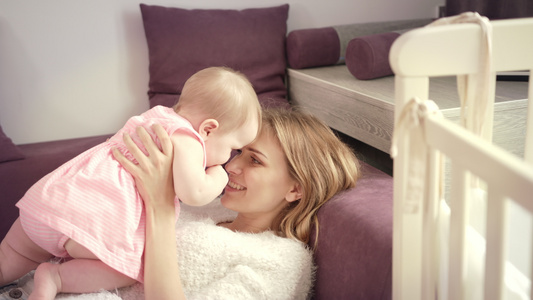 年轻母亲在家中吻婴儿表达爱与幸福概念视频