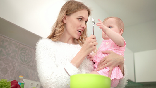 美丽的母亲和女儿一起做饭妈和孩子在厨房视频