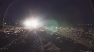 男人站在沙滩上对着车头灯7秒视频
