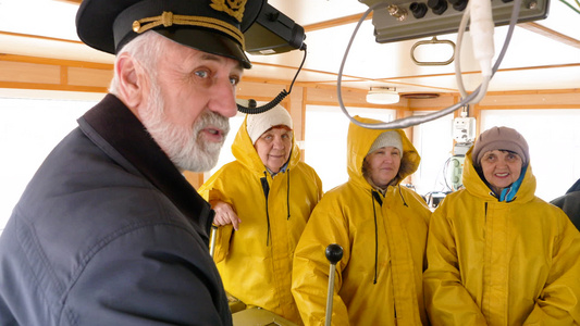 大胡子船长在导航办公室与穿着黄色制服的船队交谈女船员视频