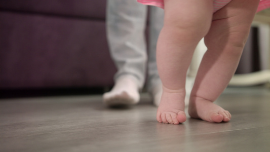 小婴儿和父亲在地板上练习走路视频