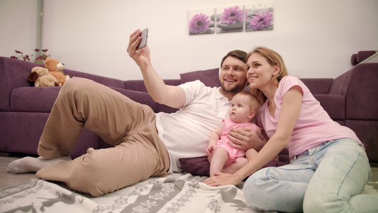 在家做自拍的庭快乐父亲和妻子女儿一起拍照视频
