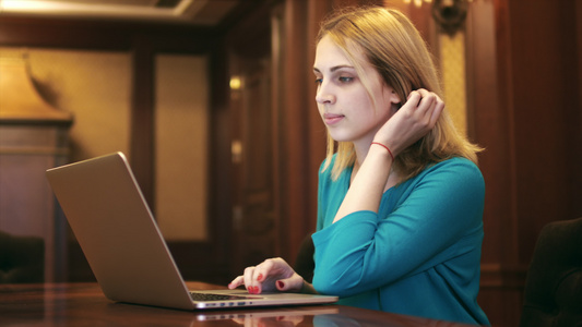 年轻妇女在屏幕上看笔记本电脑和键盘上打字[二十多岁]视频