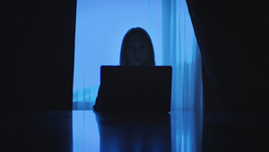 从事笔记本电脑工作的商业妇女坐在黑暗房间的窗口后坐19秒视频
