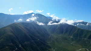 4K航拍蓝天白云高山蜿蜒小路唯美自然风光30秒视频