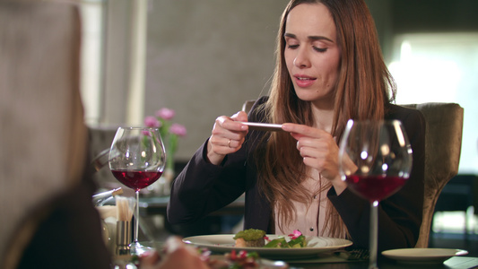在餐厅的智能手机上拍摄食物照片的女商务人士视频