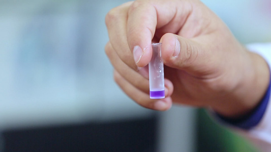 科学家手中带有紫液的实验室小瓶视频