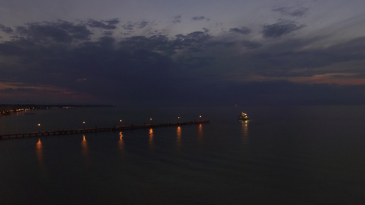 夜间飞越海码头和帆船视频