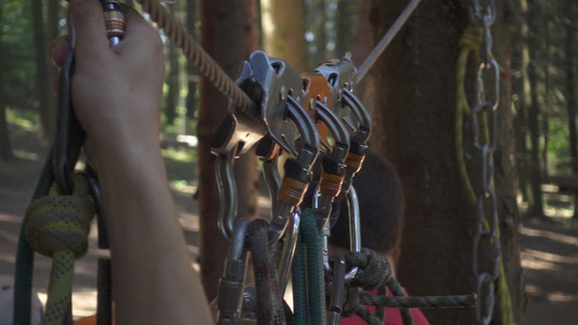 团建男性手拿着木棍绳子绑在冒险公园的极端攀爬树上视频