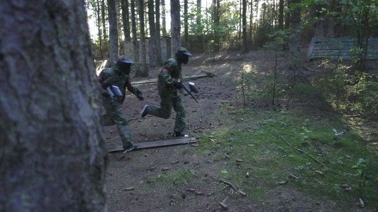 夏季森林射击比赛期间在战场上跑的彩弹球运动员视频