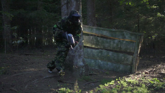 男人玩彩弹游戏枪在森林射击场上跑视频