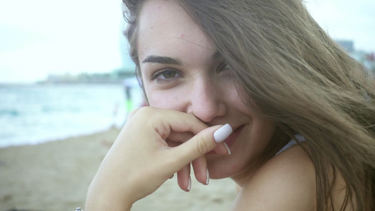 坐在沙滩上的肖像美丽女孩视频