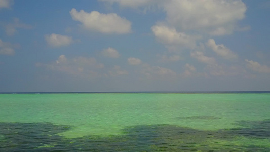 以蓝海和白沙为背景航行的海滩上宁静海岸线的海景视频