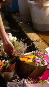 女生挑选鲜花夜晚花市鲜花售卖插花花束鲜花市场包装花束视频