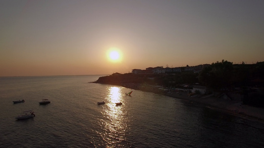 日落的度假胜地和海与船只空中三角形沙滩视频