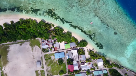 蓝绿海与亮沙背景的豪华度假村海滩时间的空中无人机性质视频