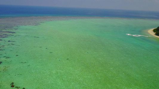 蓝水白沙背景下宁静海岸海滩时间的无人机景观视频