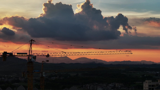 日落夕阳塔吊剪影建筑工地城市建设视频