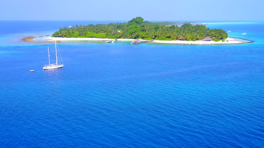 豪华的环礁湖海滩由具有白沙背景的蓝色水礁湖航行的空中视频