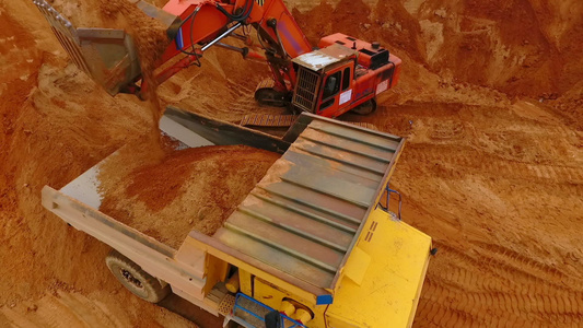 采矿挖掘机在沙石场的垃圾卡车中装载沙子[石渣]视频