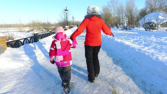在冬季公园奔跑的母女背影冬季快乐视频