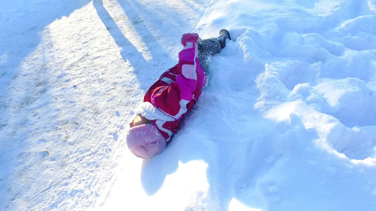 小女孩躺在雪上无忧虑视频