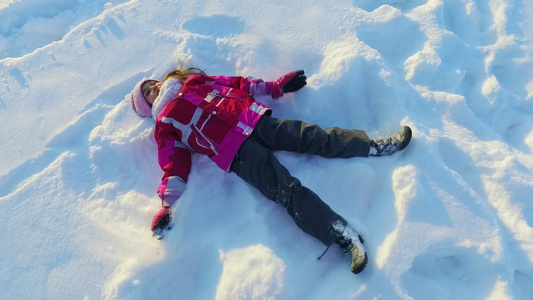风景最优的小女孩做雪天使冬季孩子日视频