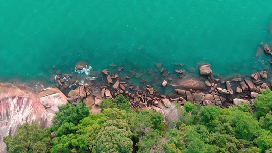 无人机射击航空摄影一个热带岛屿的石海岸的垂直顶视图视频