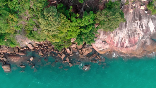 无人机射击航空摄影一个热带岛屿的石海岸的垂直顶视图视频