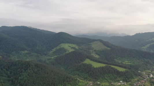 乘飞机飞到山上在夏日空中看到绿林雨后多云视频