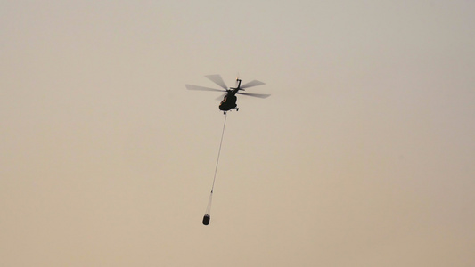 为森林火灾运送水桶的直升机视频
