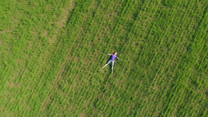 女人躺在巨大的绿色草坪上放松25秒视频