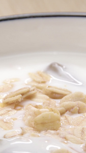 燕麦片倒进酸奶中的特写营养早餐视频