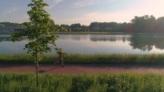 年轻健康的女人在美丽的公园里慢跑在阳光明媚的清晨与视频