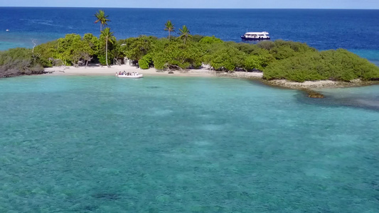 以蓝绿水和白沙背景绘制的沿海三角海岸海滩时间的空中视频