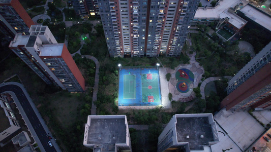 城市小区夜晚篮球场人们休闲活动航拍视频