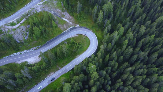 高山和绿林中绕行道路的空中航向视频