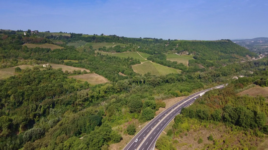 空中无人驾驶飞机飞越路边有绿植的公路视频