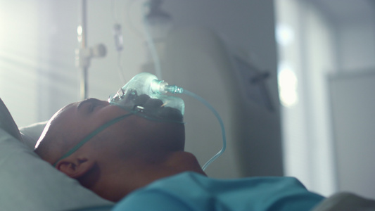 躺在床上急诊室病房特写的带氧气面罩的康复患者。视频