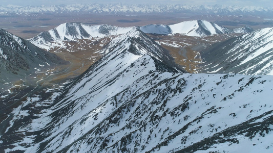 在晴天的雪山鸟瞰图无人机正飞越山脊相机正在向上倾斜视频