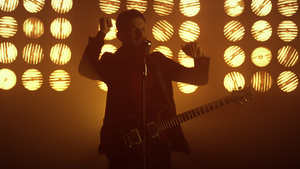 吉他手在聚光灯下唱歌享受过程8秒视频